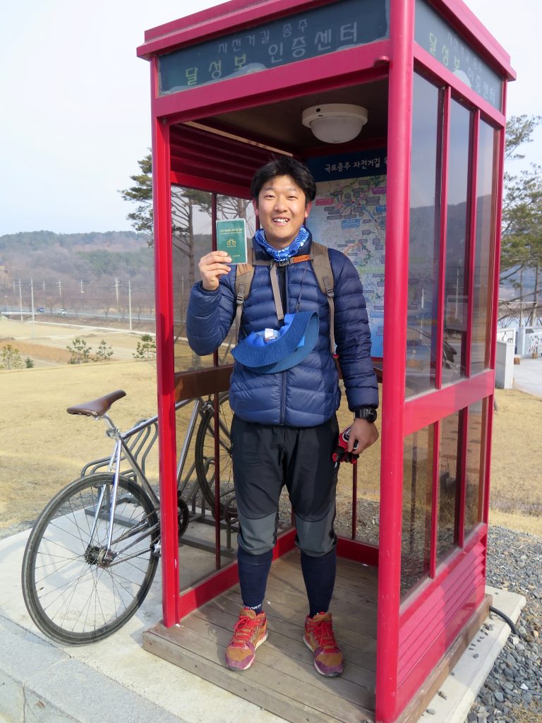 Jeff, amigo que fiz durante a viagem, orgulhoso com seu passaporte em uma das cabines de certificação na Ciclovia Seul - Busan - Coréia do Sul