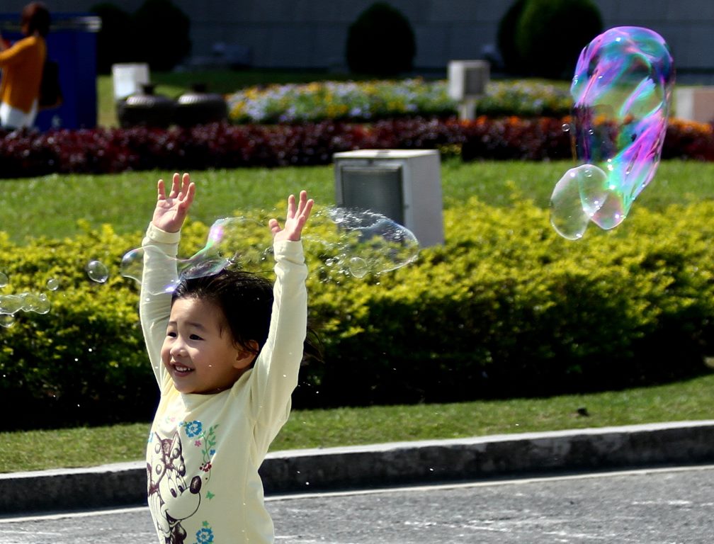 Criança brincando com bolhas de sabão no feriado de 228 Memorial Day na Praça da Liberdade. Taipei - Taiwan.