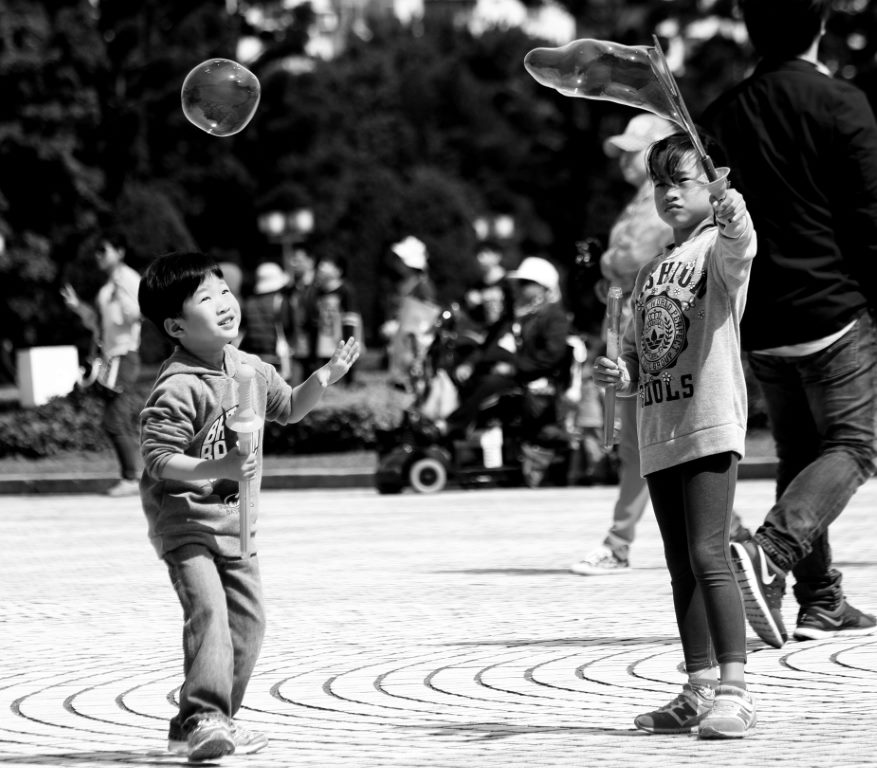 Irmãos brincando com bolhas de sabão no feriado de 228 Memorial Day na Praça da Liberdade. Taipei - Taiwan.