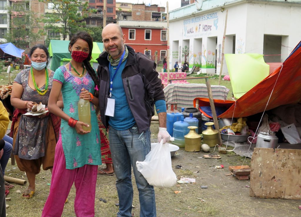 Menina segura uma garrafa de água em acampamento de desabrigados em Kathmandu - Nepal